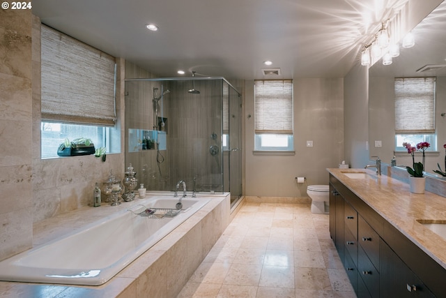 full bathroom featuring double sink vanity, tile floors, toilet, and a wealth of natural light