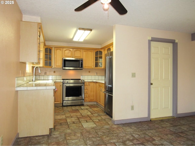 kitchen featuring sink, tile counters, light brown cabinets, and appliances with stainless steel finishes