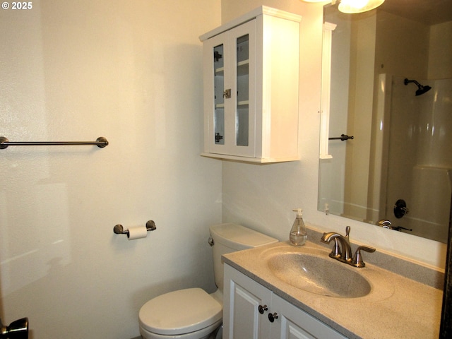 bathroom featuring vanity, toilet, and a shower