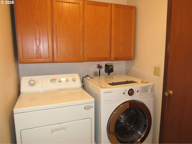 washroom featuring cabinets and washer and clothes dryer