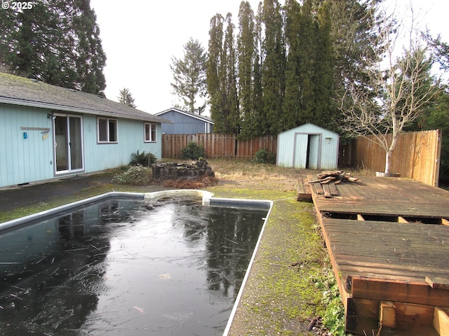 view of yard with a pool side deck and a storage unit