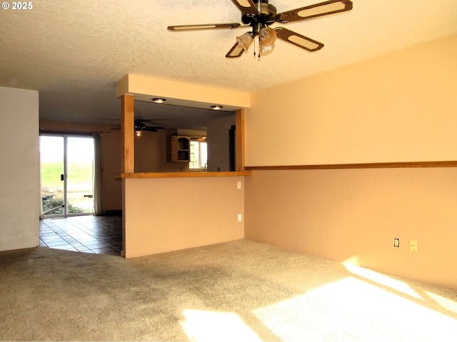 carpeted spare room with ceiling fan and a textured ceiling