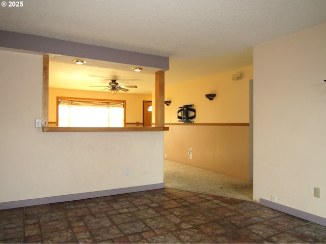 empty room with a textured ceiling and ceiling fan