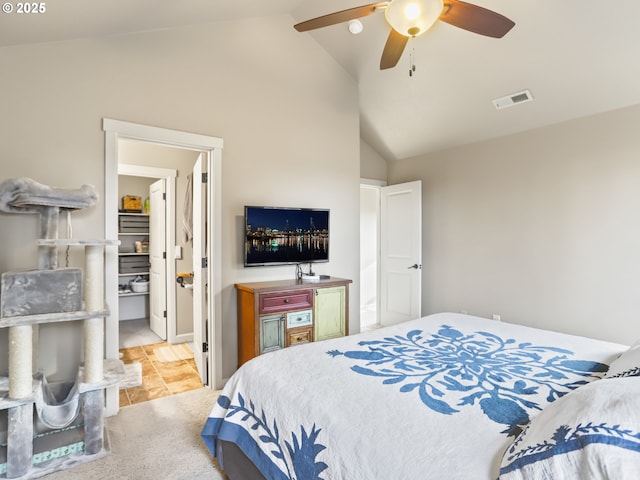 bedroom with a ceiling fan, visible vents, vaulted ceiling, and light carpet