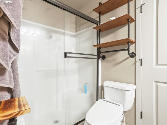 bathroom with toilet and an enclosed shower