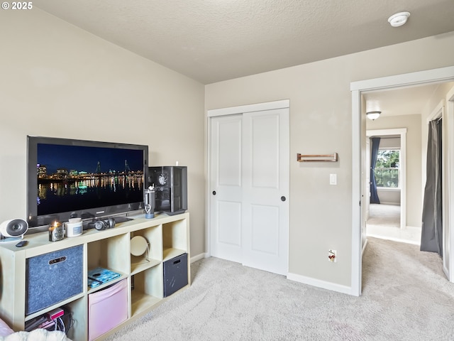 interior space featuring light colored carpet and a textured ceiling