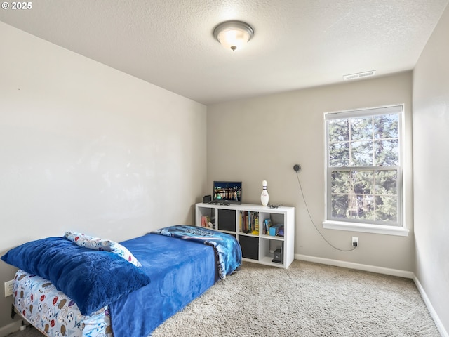 bedroom featuring carpet floors, baseboards, visible vents, and a textured ceiling