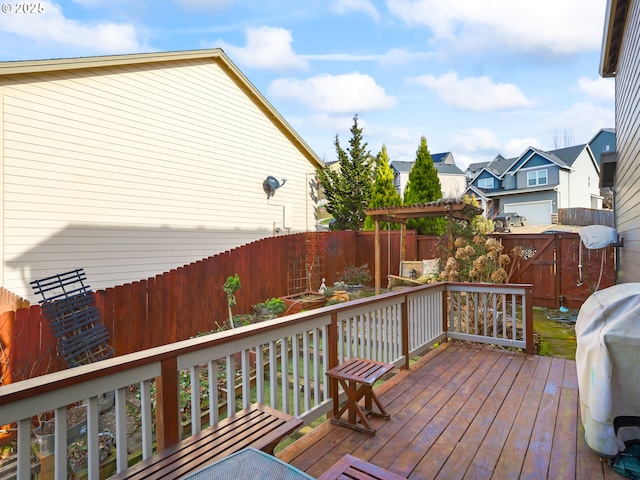 wooden deck featuring a residential view, a fenced backyard, and a grill