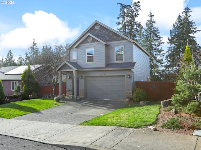 craftsman inspired home with concrete driveway, stone siding, an attached garage, fence, and a front yard