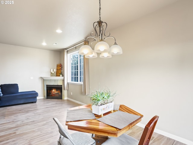 dining area with an inviting chandelier and light hardwood / wood-style floors