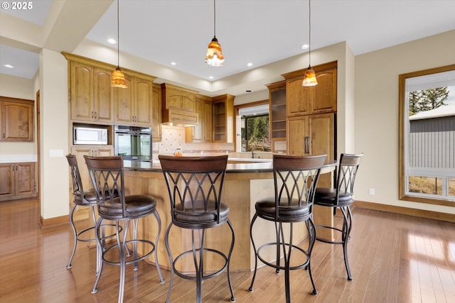 kitchen featuring open shelves, wall oven, baseboards, white microwave, and light wood finished floors