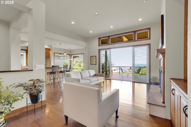 living area featuring baseboards, a fireplace, recessed lighting, and hardwood / wood-style floors