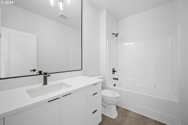 full bathroom with toilet, vanity, wood-type flooring, and washtub / shower combination