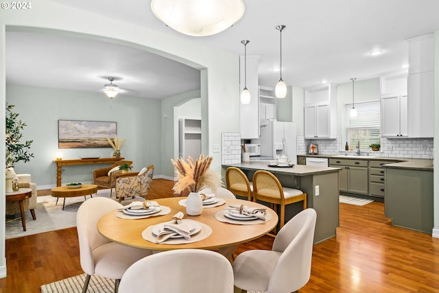 dining area with ceiling fan, dark hardwood / wood-style flooring, and sink