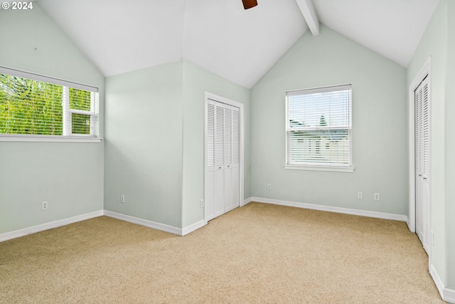 unfurnished bedroom with vaulted ceiling with beams, ceiling fan, and light colored carpet