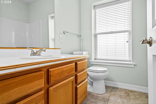 bathroom featuring walk in shower, vanity, toilet, and a wealth of natural light