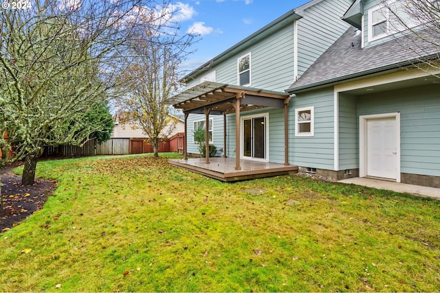 rear view of property with a yard, a pergola, and a wooden deck