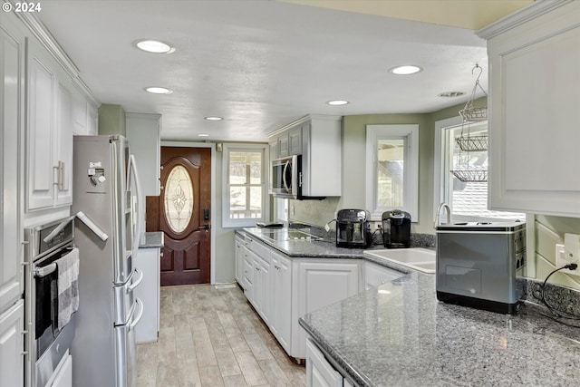 11635 NW Seavey Rd, Forest Grove, OR 97116 - kitchen with appliances with stainless steel finishes, white cabinets, recessed lighting, a sink, and light wood-type flooring