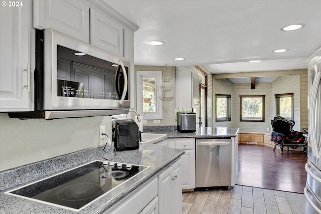 11635 NW Seavey Rd, Forest Grove, OR 97116 - kitchen with stainless steel appliances, white cabinetry, light wood-style flooring, recessed lighting, and light stone counters