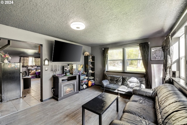 11635 NW Seavey Rd, Forest Grove, OR 97116 - living room with healthy amount of natural light, a glass covered fireplace, wood finished floors, a textured ceiling, and baseboards