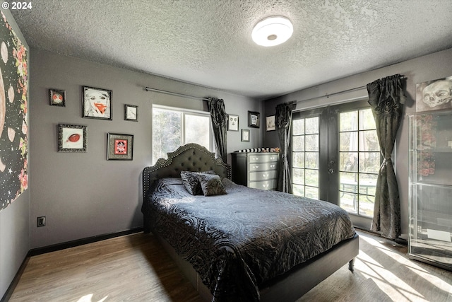 11635 NW Seavey Rd, Forest Grove, OR 97116 - bedroom with french doors, wood finished floors, a textured ceiling, and baseboards