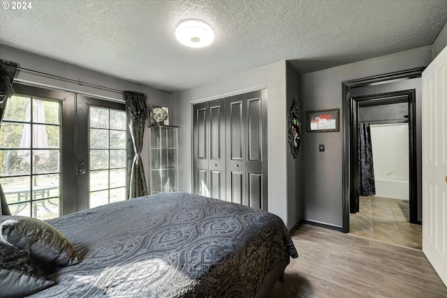 11635 NW Seavey Rd, Forest Grove, OR 97116 - bedroom with french doors, a textured ceiling, a closet, light wood-style floors, and baseboards