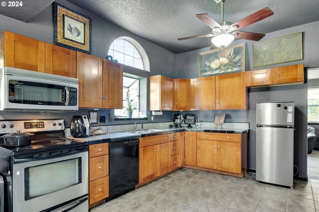 11635 NW Seavey Rd, Forest Grove, OR 97116 - kitchen featuring stainless steel appliances, tile countertops, plenty of natural light, a sink, and a textured ceiling