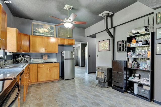 11635 NW Seavey Rd, Forest Grove, OR 97116 - kitchen with a sink, freestanding refrigerator, ceiling fan, a textured ceiling, and a wood stove