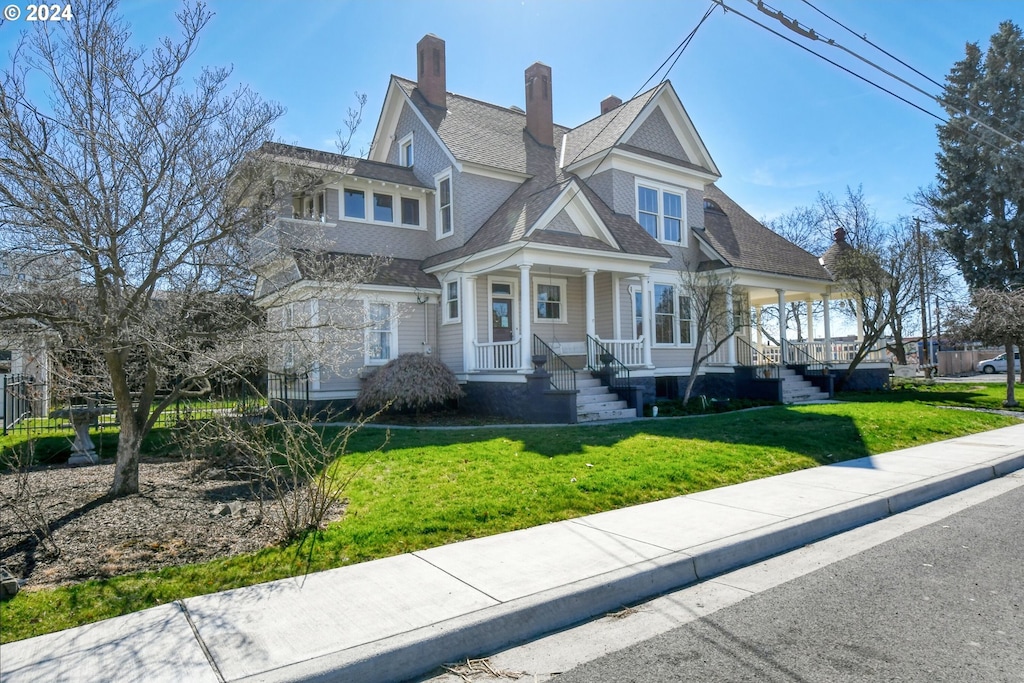 view of front of home featuring covered porch and a front lawn