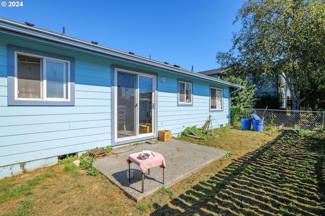 back of house featuring a lawn and a patio