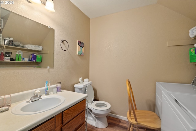 bathroom with lofted ceiling, toilet, vanity, washer and dryer, and hardwood / wood-style flooring