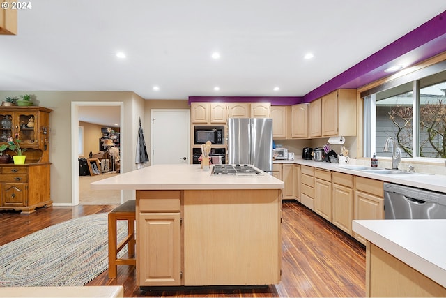 kitchen featuring hardwood / wood-style floors, appliances with stainless steel finishes, a center island, and light brown cabinets