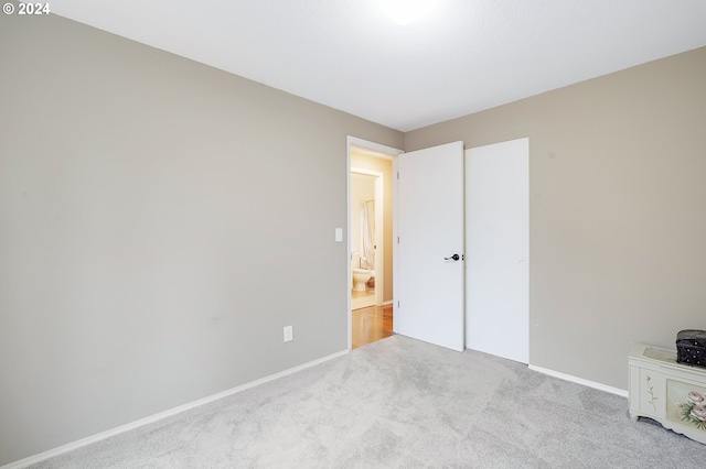 unfurnished bedroom featuring light carpet