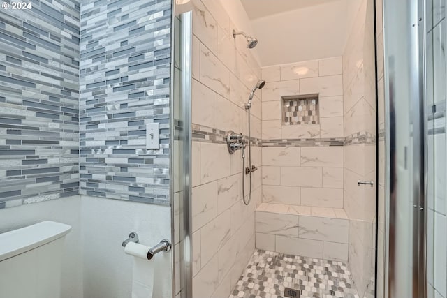 bathroom featuring walk in shower and toilet