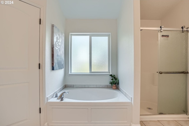 bathroom with tile patterned floors and shower with separate bathtub