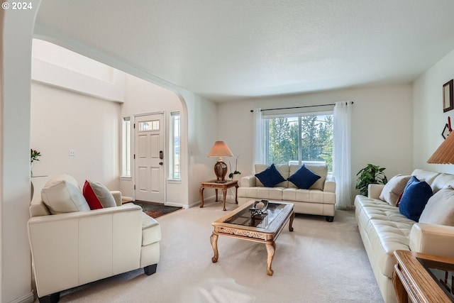 carpeted living room featuring a textured ceiling