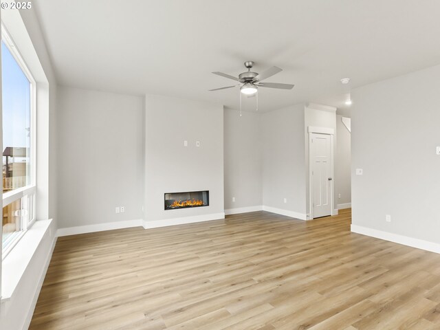 kitchen featuring stainless steel appliances, sink, light wood-type flooring, backsplash, and light stone countertops