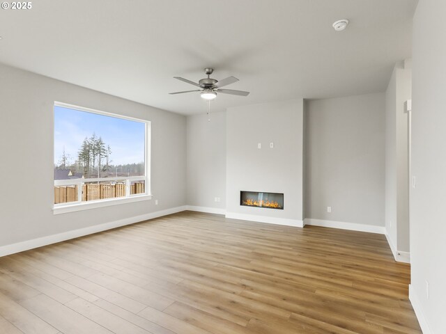 unfurnished living room featuring ceiling fan and light hardwood / wood-style flooring