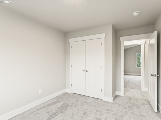 unfurnished bedroom with a closet and light carpet