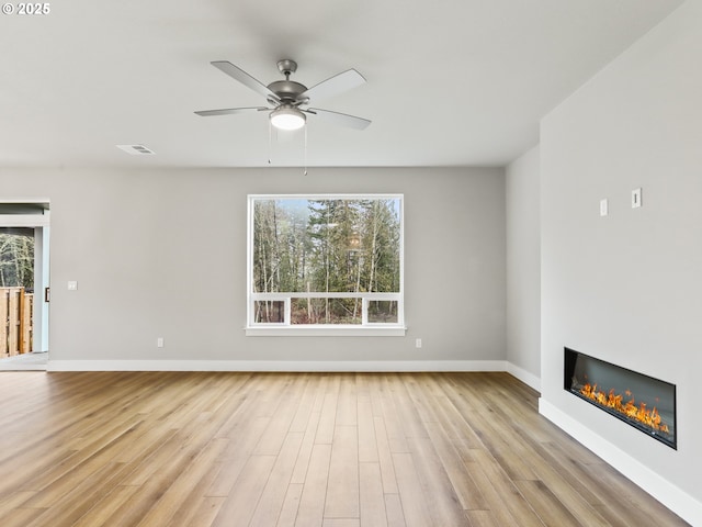 unfurnished living room featuring ceiling fan, light hardwood / wood-style flooring, and plenty of natural light