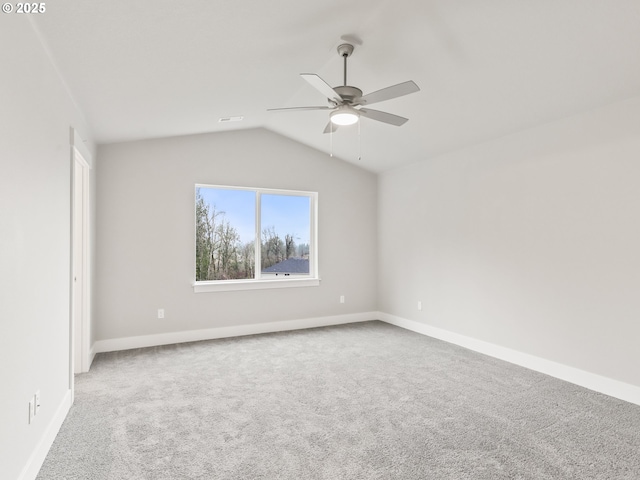 empty room featuring lofted ceiling, carpet flooring, and ceiling fan