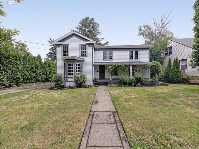 traditional-style home featuring a porch and a front lawn