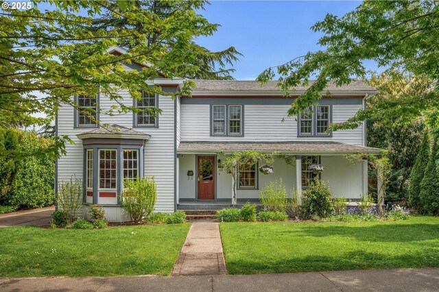 traditional-style home with a front lawn and covered porch