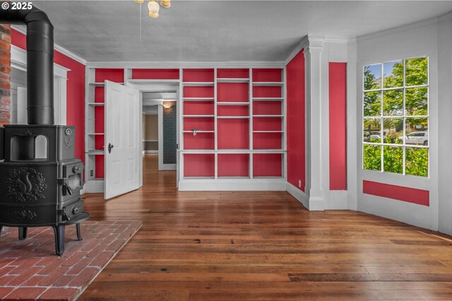 bathroom featuring baseboards, a freestanding tub, crown molding, and toilet
