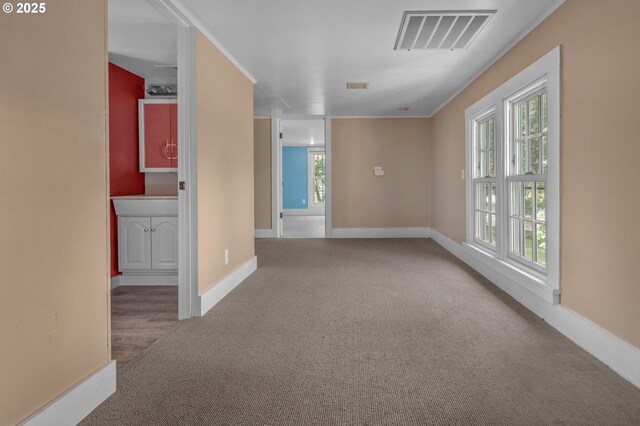 spare room with baseboards, dark carpet, and visible vents