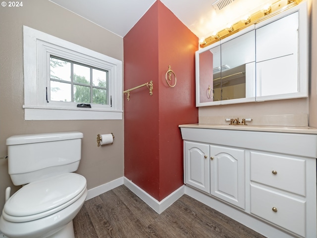 bathroom with toilet, hardwood / wood-style flooring, and vanity