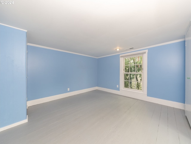 empty room featuring ornamental molding and hardwood / wood-style flooring