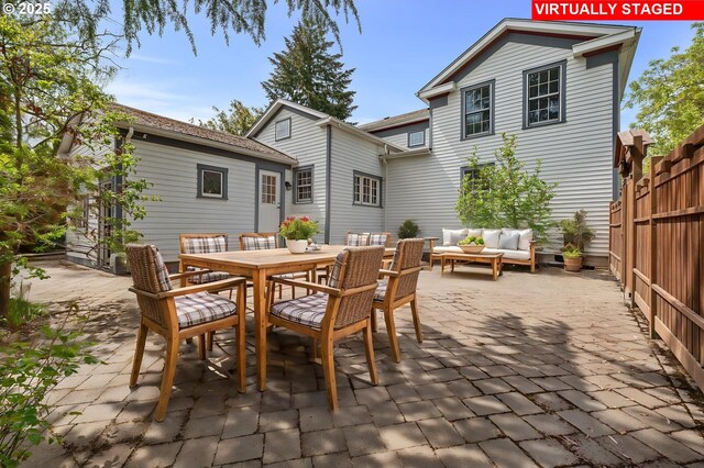 back of house featuring fence, an outbuilding, central AC unit, and a patio area