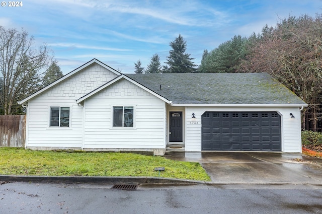 single story home with a garage, driveway, fence, and roof with shingles