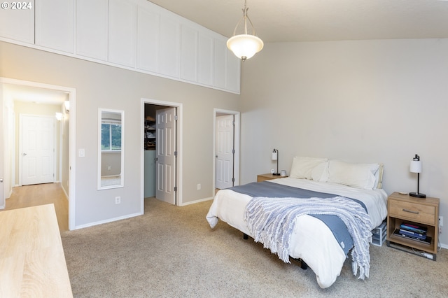 bedroom featuring a high ceiling, light colored carpet, and baseboards